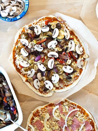 Rezept Foto vom Grillpizza und Ofenpizza. Das Foto zeigt die frisch belegten Pizzen bevor sie gleich in den Ofen kommen.