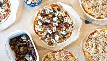 Rezept Foto vom Grillpizza und Ofenpizza. Das Foto zeigt die frisch belegten Pizzen bevor sie gleich in den Ofen kommen.