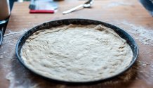 Rezept Foto Holzofenpizza Schritt für Schritt im Holzofen backen. Das Foto zeigt zwei Pizzableche die mit Pizzateig gefüllt und bereit für den Sugo sind.