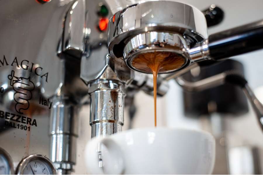 Rezept Foto Eierlikör Tiramisu. Der bodenlose Siebträger bereitet den Espresso zu, dicke Crema läuft aus und die kleine Espresso Tasse füllt sich mit dem Kaffee.