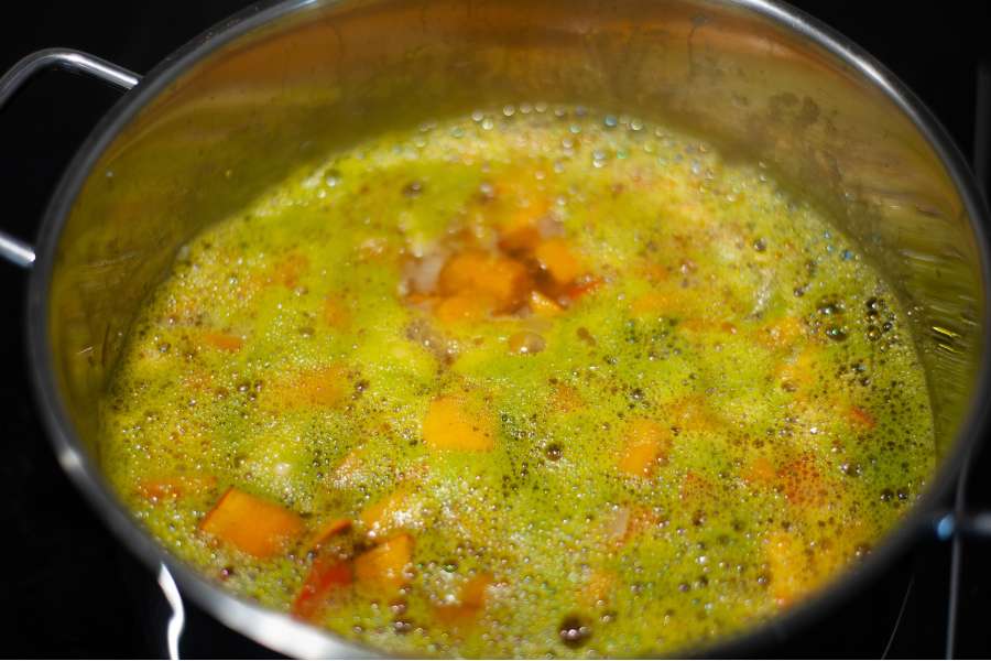 Rezept Foto Kürbis Creme Suppe alle Zutaten schmoren im Topf mit der Gemüsebrühe