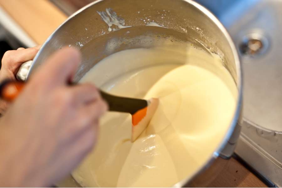 Rezept Foto Russischer Zupfkuchen. Nahaufnahme Katharina rührt gerade die Creme Füllung mit einem Schaumlöffel durch.