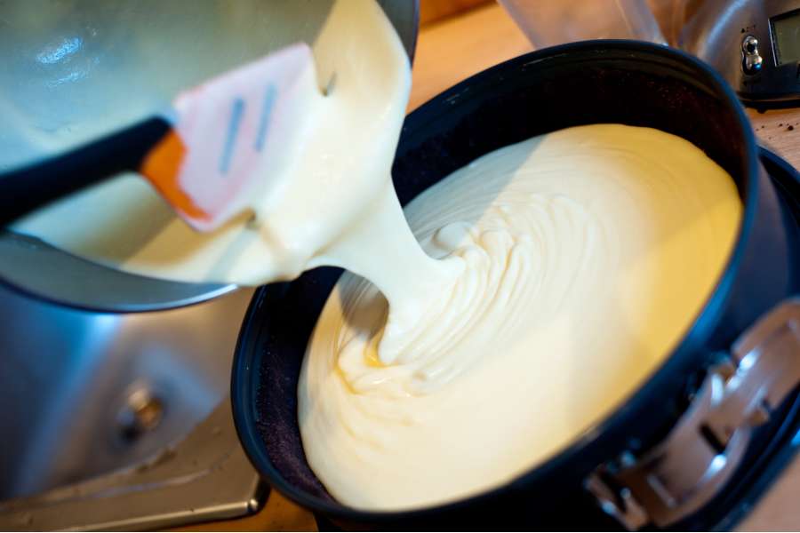 Rezept Foto Russischer Zupfkuchen. Nahaufnahme: Die Vanillepudding Füllung wird gerade aus der Schüssel auf den Boden gekippt.
