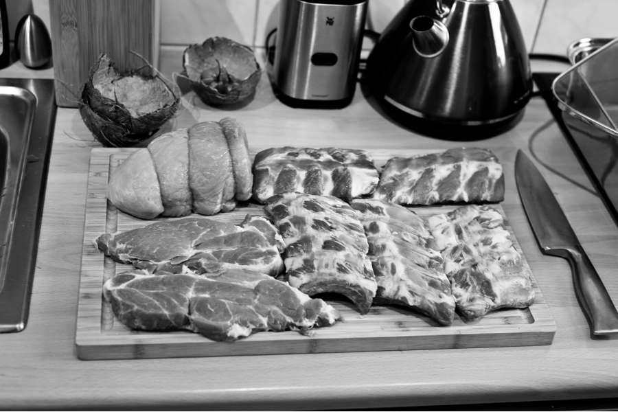 Rezept Foto Bayerischer Schweinebraten in der Kümmelbiersoße. Das frische Schweinefleisch liegt bereit um mit den Gewürzen bestreut zu werden. Schälrippchen, Schweinebauch, Spanferkl Rollbraten werden gleich mit Gewürzen einbalsamiert.