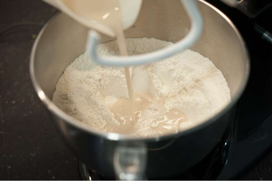 Rezept Foto Grillpizza und Ofenpizza Italien. Das Wasser wird zum Mehl in die Rührschüssel gekippt.