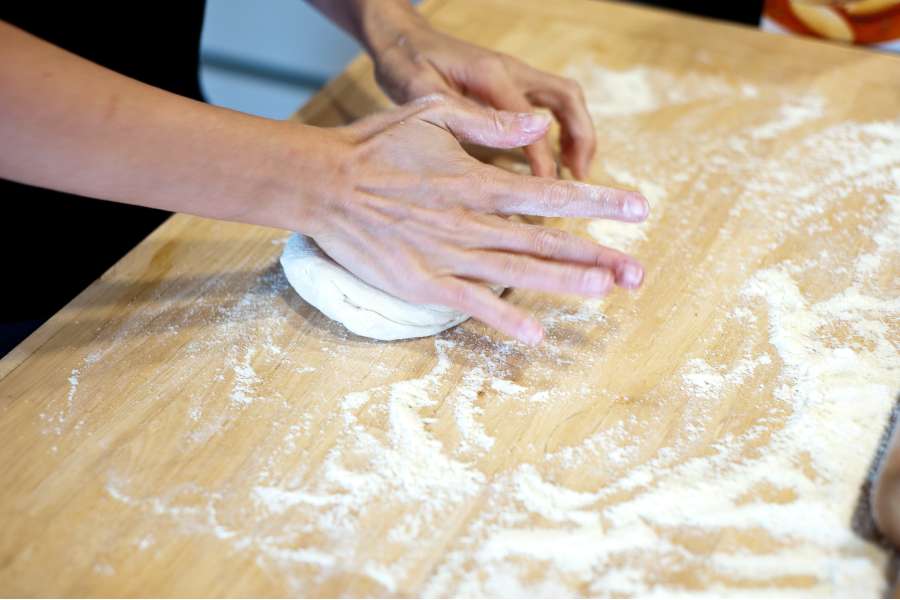 Rezept Foto Grillpizza und Ofenpizza Italien. Katharina knetet und formt den Teig mit Ihren Händen.